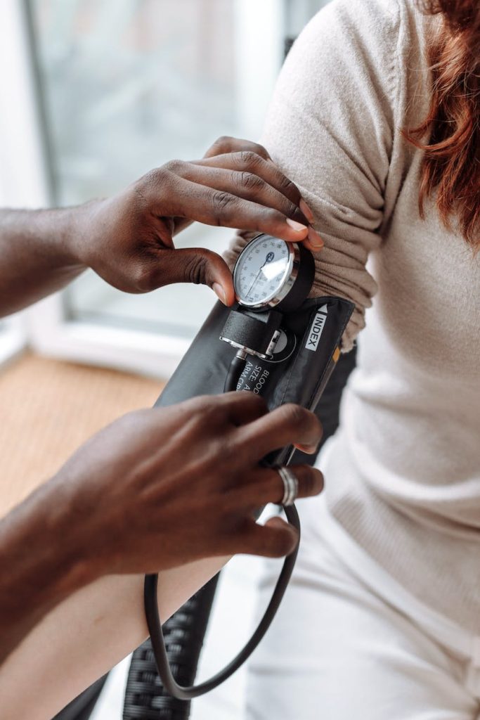 a person checking the blood pressure of the patient